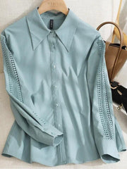 Une femme modèle une tenue de mode comprenant un Chemisiers Évider bleu tiffany Vanissy avec des détails en dentelle sur les épaules, une jupe taille haute noire et un sac à main blanc à maillons de chaîne. Seul son torse jusqu'à ses cuisses est visible.